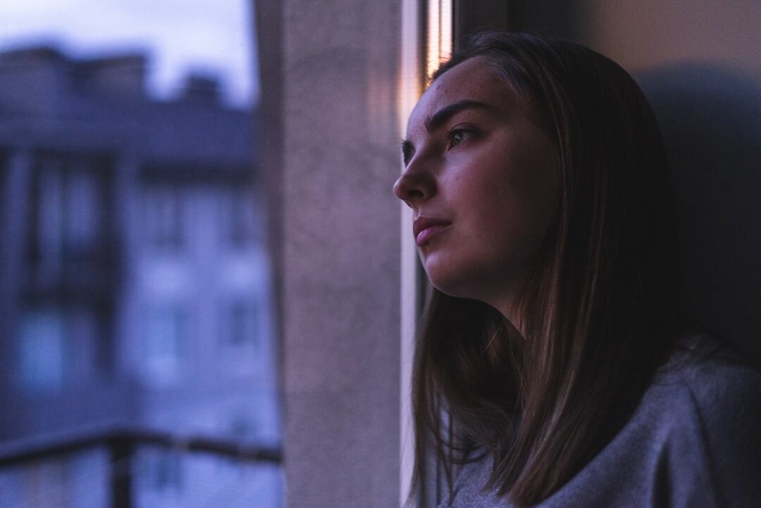 young woman looking out window